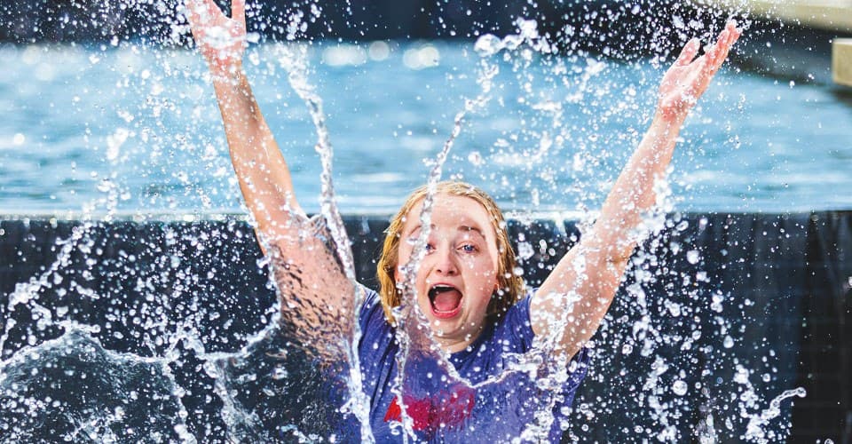 Student splashing in the ODK Fountain