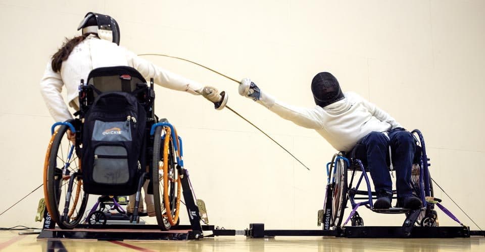 Two fencers fence in wheelchairs