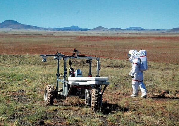 student helps test rover in desert