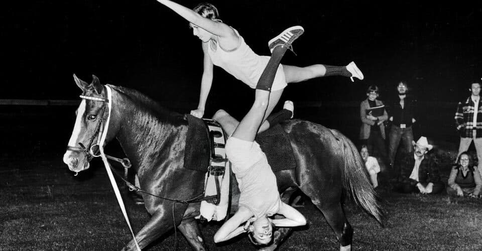 two women perform equestrian gymnastics