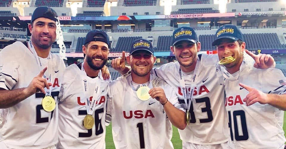 five Team USA lacrosse players pose with gold medals